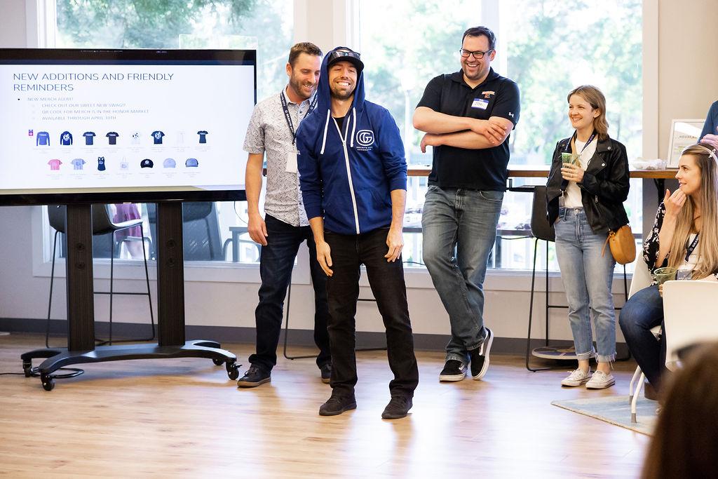 Community event with group laughing at presentation at Granite City Workspaces event space