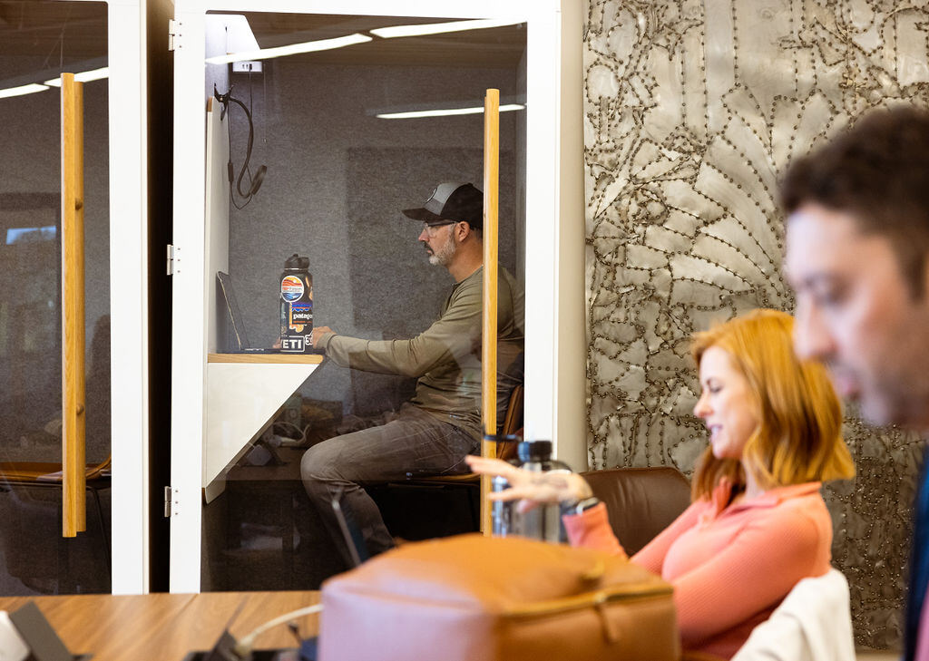Member on a focused laptop call inside a private phone booth at Granite City Workspaces
